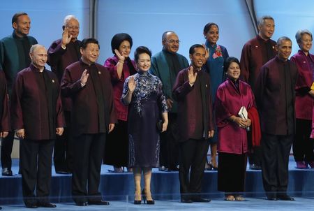 © Reuters. Russian President Vladimir Putin and U.S. President Barack Obama stand with Chinese President Xi Jinping and other leaders during the APEC Summit family photo in Beijing