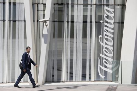 © Reuters. A man walks past a Telefonica building in Barcelona