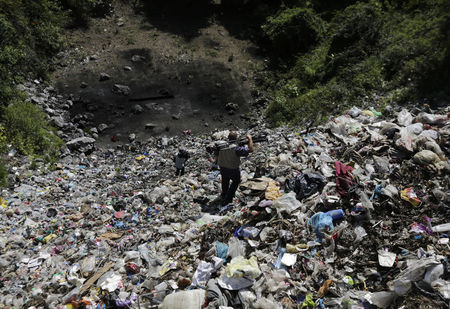 © Reuters. Television cameramen walk at a garbage dump where remains were found outside the mountain town of Cocula, near Iguala in the southwestern state of Guerrero