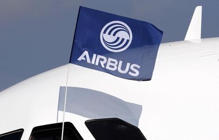 © Reuters. A flight test engineer holds an Airbus Group flag after the first flight of the Airbus A320neo in Colomiers near Toulouse