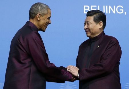 © Reuters. U.S. President Obama shakes hands with China's President Xi during the APEC Welcome Banquet at Beijing National Aquatics Center, or the Water Cube, in Beijing