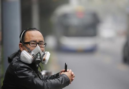 © Reuters. Un uomo indossa una maschera anti-gas ad una dermata dell'autobus a Pechino 