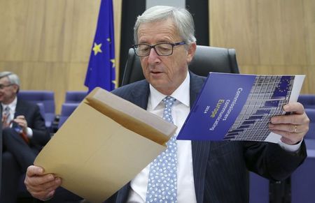 © Reuters. The European Commission's new President Juncker opens an envelope as he chairs the first official meeting of the EU's executive body in Brussels