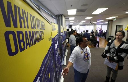 © Reuters. Julian Gomez explains Obamacare to people at a health insurance enrolment event in Commerce