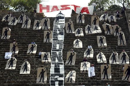 © Reuters. Ativista de uma organização chamada Comuna fazem protesto em que seguram silhuetas representando 43 estudantes desaparecidos no México, no sítio arqueológico de Monte Alban, em Oaxaca