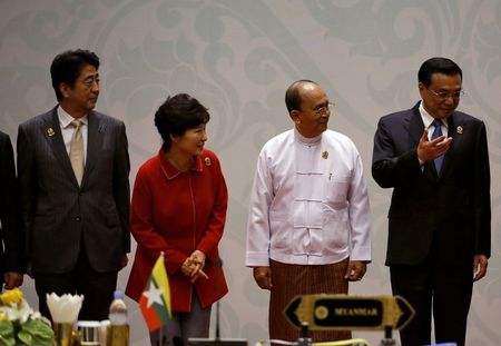 © Reuters. Japan's Prime Minister Shinzo Abe, South Korea's President Park Geun-Hye, Myanmar's President Thein Sein listen as China's Premier Li Keqiang talks during a family photo before the ASEAN Plus Three Summit