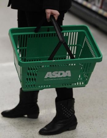 © Reuters. A shopper carries a shopping basket at an ASDA supermarket in Oldham