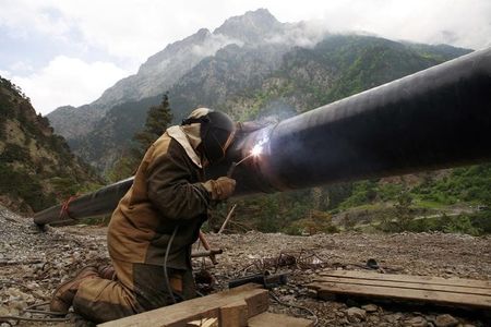 © Reuters. Сварщик скрепляет трубы газопровода у поселка Бурон в Северной Осетии