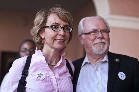 © Reuters. Former Congresswoman Giffords and Congressman Barber leave after casting their ballots in downtown Tucson