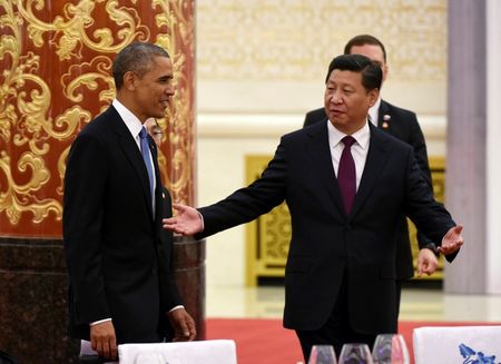 © Reuters. Chinese President Xi Jinping gestures to U.S. President Barack Obama as they arrive for a lunch banquet in the Great Hall of the People in Beijing