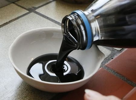 © Reuters. Работник лаборатории компании Красноярскнефтепродукт наливает нефть в емкость для проверки ее качества
