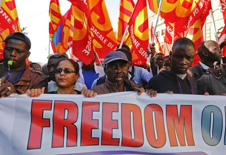 © Reuters. Protesters hold a banner during a rally against a government labour reform in Rome