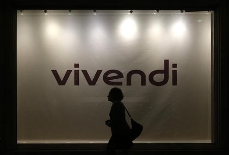© Reuters. A woman is silhouetted as she walks past the main entrance of the entertainment-to-telecoms conglomerate Vivendi's headquarters in Paris