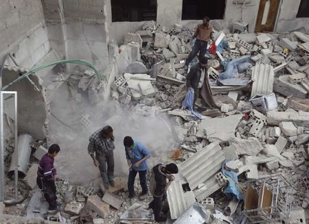 © Reuters. Residents search for belongings amongst rubble of damaged buildings after what activists said was an airstrike by forces loyal to Syria's President Assad, in the Damascus suburb of Saqba