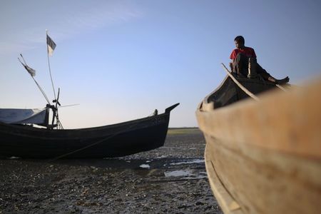 © Reuters. Rohingya fishermen passes the time among boats at Thae Chaung refugee camp outside Sittwe