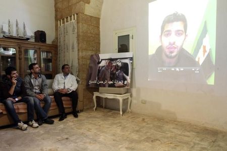 © Reuters. Former colleague of U.S. aid worker Abdul-Rahman Kassig, is seen on a projection screen as he speaks from Sweden during a news conference calling for Kassig's release in Tripoli, northern Lebanon