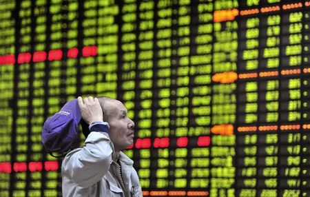 © Reuters. An investor looks at an electronic board showing stock information at a brokerage house in Jiujiang