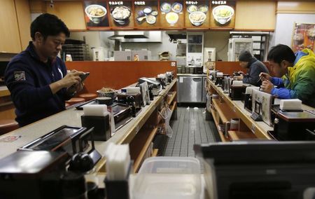 © Reuters. Customers eat at midnight at a beef bowl fast food restaurant in Tokyo