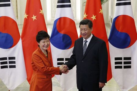 © Reuters. China's President Xi shakes hands with South Korea's President Park in front of Chinese and South Korean national flags during a meeting at the Great Hall of the People, on the sidelines of the Asia Pacific Economic Cooperation (APEC) meetings, 