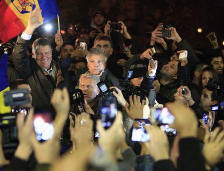 © Reuters. Il nuovo presidente romeno Klaus Iohannisnella notte a Bucarest festeggia insieme ai suoi sostenitori