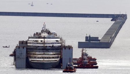 © Reuters. Tug boats push the Costa Concordia ship inside Genoa's port, in northern Italy, where the ship will be broken up for scrap