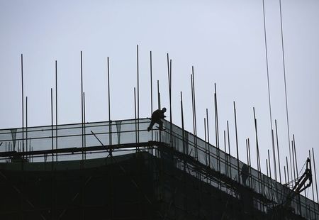 © Reuters. Man works at a construction site of a new building in Beijing