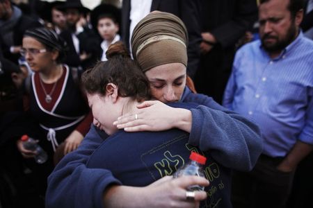 © Reuters. Israelis mourn during the funeral of Aryeh Kopinsky, Calman Levine and Avraham Shmuel Goldberg in Jerusalem