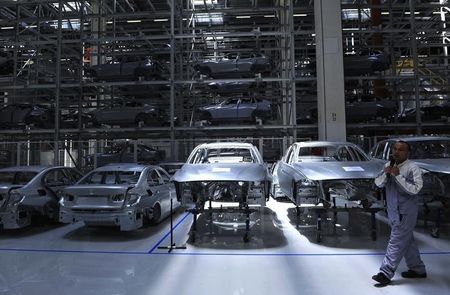 © Reuters. An employee guides visitors inside a BMW factory in Shenyang