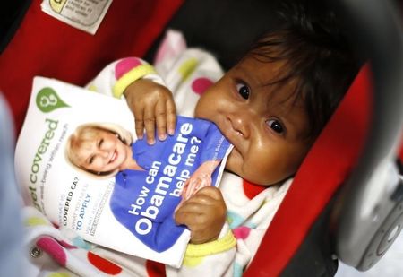 © Reuters. Hazel Garcia chews a pamphlet at a health insurance enrollment event in Cudahy, California