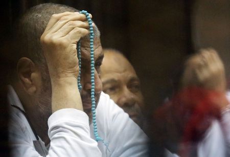 © Reuters. Deputy leader of Egypt's Muslim Brotherhood Khairat El-Shater reacts as he stands behind bars during his trial on charges of spying and terrorism at a court in the police academy on the outskirts of Cairo