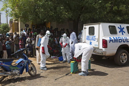 © Reuters. Trabajadores de Salud se colocan trajes protectores fuera de una mezquita antes de desinfectarla. Bamako. Nociembre 14, 2014. Las autoridades sanitarias españolas dijeron el jueves que han detectado un posible contagio de ébola en una cooperante sanitaria que tuvo un contacto de alto riesgo con un paciente enfermo en Mali y han decidido repatriarla para ponerla en cuarentena en España   