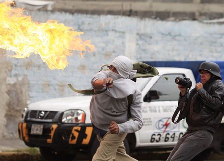 © Reuters. A masked demonstrator throws a petrol bomb towards riot police during a protest over the 43 missing Ayotzinapa students, near the Benito Juarez International airport in Mexico City
