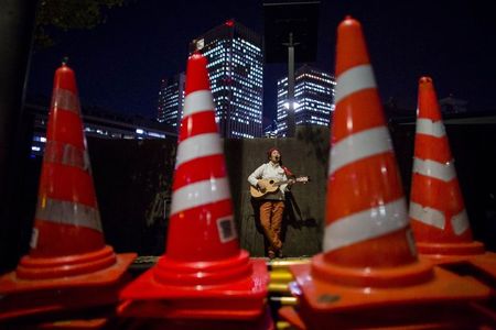 © Reuters. An anti-nuclear energy protester plays the guitar and sings songs opposite Japan's national parliament building in Tokyo