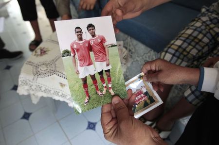 © Reuters. Fethi Selmi shows a photo of her son Nidhal, a youth who was killed during fighting in Syria, during an interview with Reuters in Sousse
