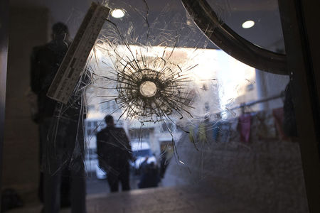 © Reuters. Jewish worshippers pray at a synagogue in Jerusalem where two militants killed four rabbis and a policeman