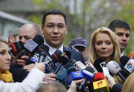 © Reuters. Romania's Prime Minister Ponta speaks to the media next to his wife Daciana Sarbu after casting his vote at a polling station in Bucharest 