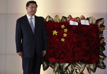 © Reuters. China's President Xi stands next to a flower arrangement depicting China's national flag, in Caracas