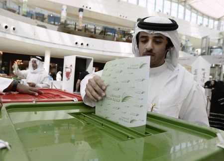 © Reuters. A voter casts his vote during parliamentary elections, at a polling station set up at the Seef Mall shopping centre in Manama