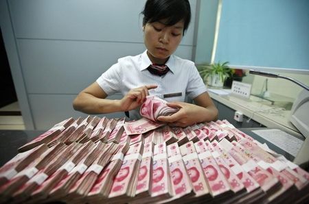 © Reuters. A bank clerk counts Chinese yuan banknotes at a branch of Industrial and Commercial Bank of China in Huaibei