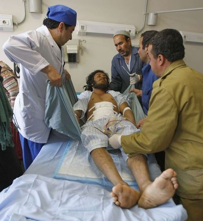 © Reuters. Medics treat a man who was wounded during a suicide attack, at a military hospital in Kabul