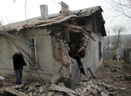 © Reuters. Man exits a house damaged by recent shelling in Krasnyi Pakhar village near Donetsk, eastern Ukraine