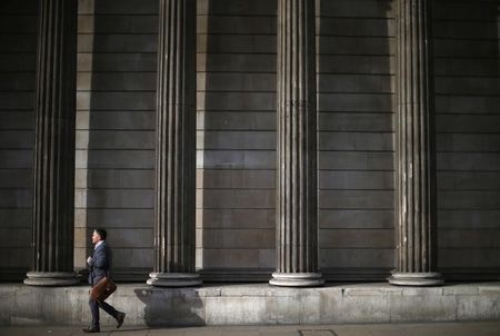© Reuters. A man walks past the columns of the Bank of England in the city of London