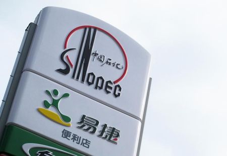© Reuters. A Sinopec logo is seen on top of a logo of Easy Joy store at a gas station in Beijing