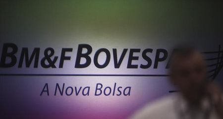 © Reuters. Homem fala ao celular com o logo da BM&FBovespa ao fundo, em São Paulo