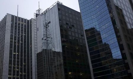 © Reuters. Funcionários suspensos por cordas trabalham em prédio na Avenida Paulista