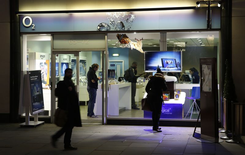 © Reuters. People pass an O2 store in central London