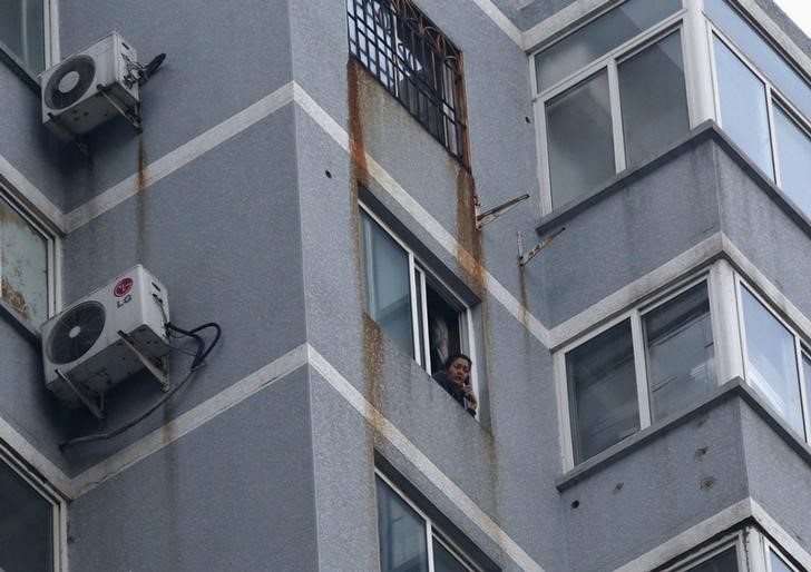 © Reuters. Guzailai Nu'er, the wife of Ilham Tohti, speaks as she has an interview with Reuters by a phone from window of her house in Beijing