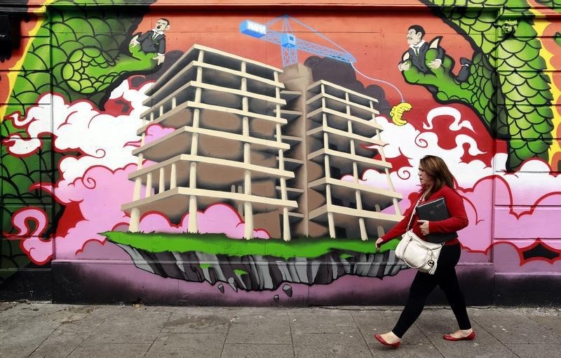 © Reuters. A woman walks past graffiti in Central Dublin