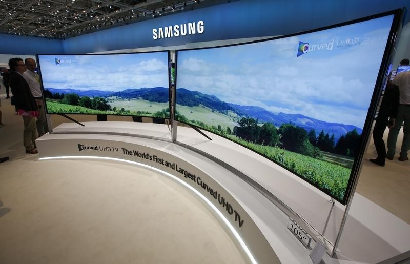 © Reuters. Visitors stand in front of Samsung's 105" Curved UHD TV screens at the IFA consumer technology fair in Berlin