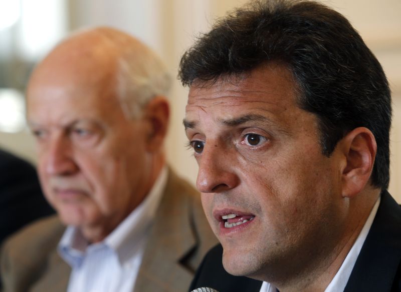 © Reuters. Massa, presidential candidate for the Frente Renovador party, listens to a question next to former economy minister Lavagna during a meeting with foreign correspondents in Tigre